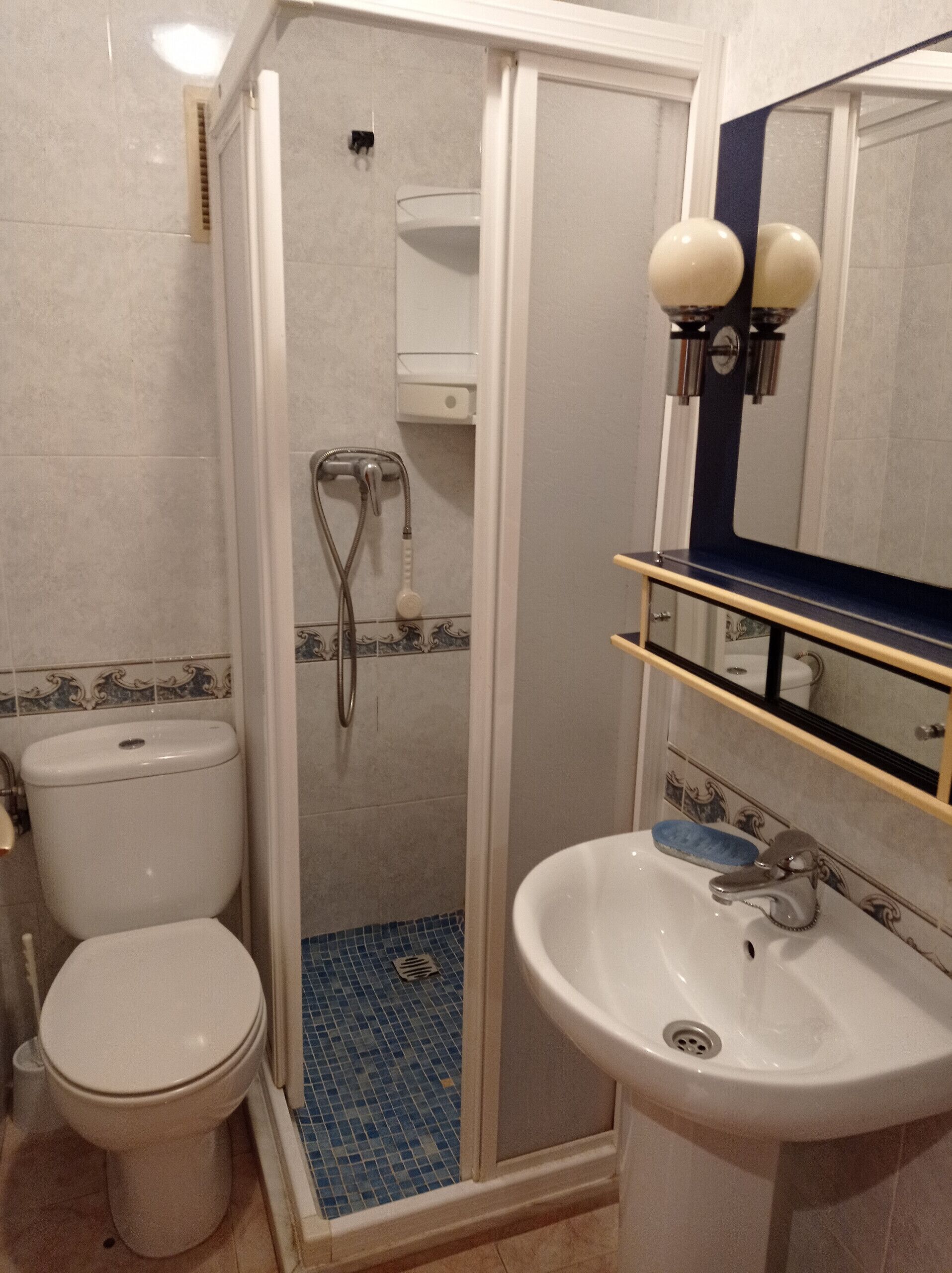 Ein Badezimmer mit Toilette, Waschbecken und Dusche.