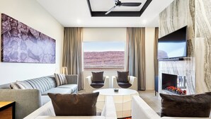 Una sala de estar moderna con un sofá, sillones, una mesa de centro, un televisor de pantalla plana y una chimenea.