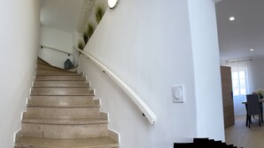 A staircase with a handrail, a dining area with a table and chairs, and a window with curtains. - 2 Bedroom Apartment in Antibes (Antibes)