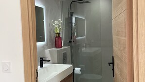 A modern bathroom with a glass shower enclosure, a white sink, and a toilet. - 2 Bedroom Apartment in Antibes (Antibes)