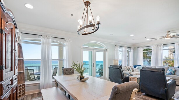 A spacious living room with a large wooden table, comfortable seating, and a view of the ocean. - Incredible 4BD, 3BA, GULF-FRONT, LG. PATIO, POOL, GRILL, PRIVATE BEACH (Santa Rosa Beach)