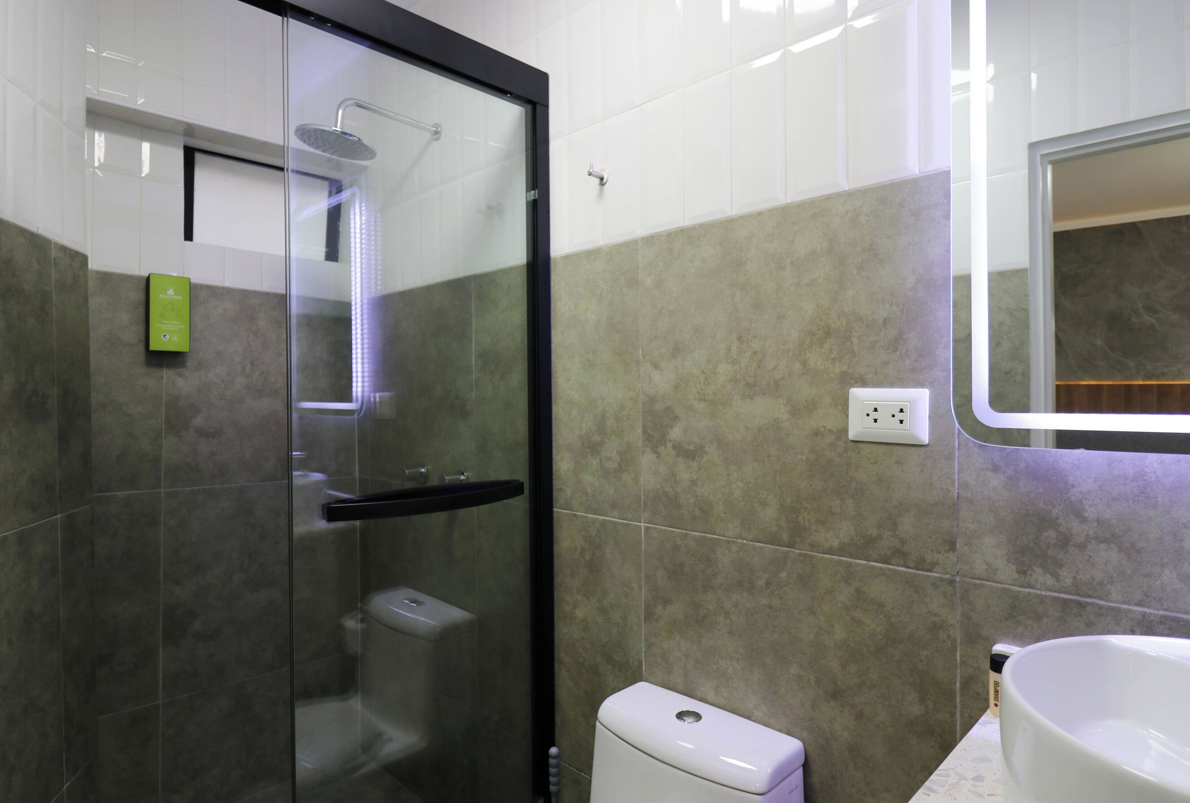 A modern bathroom with a glass-enclosed shower, a toilet, and a sink.