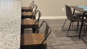 A conference room with a long table and chairs, carpeted floor, and a plain wall.