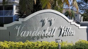 A sign for Vanderbilt Villas with a modern design and a curved top. - Perfect Getaway! Naples, Walk To Vanderbilt Beach -Immaculate! (Naples)