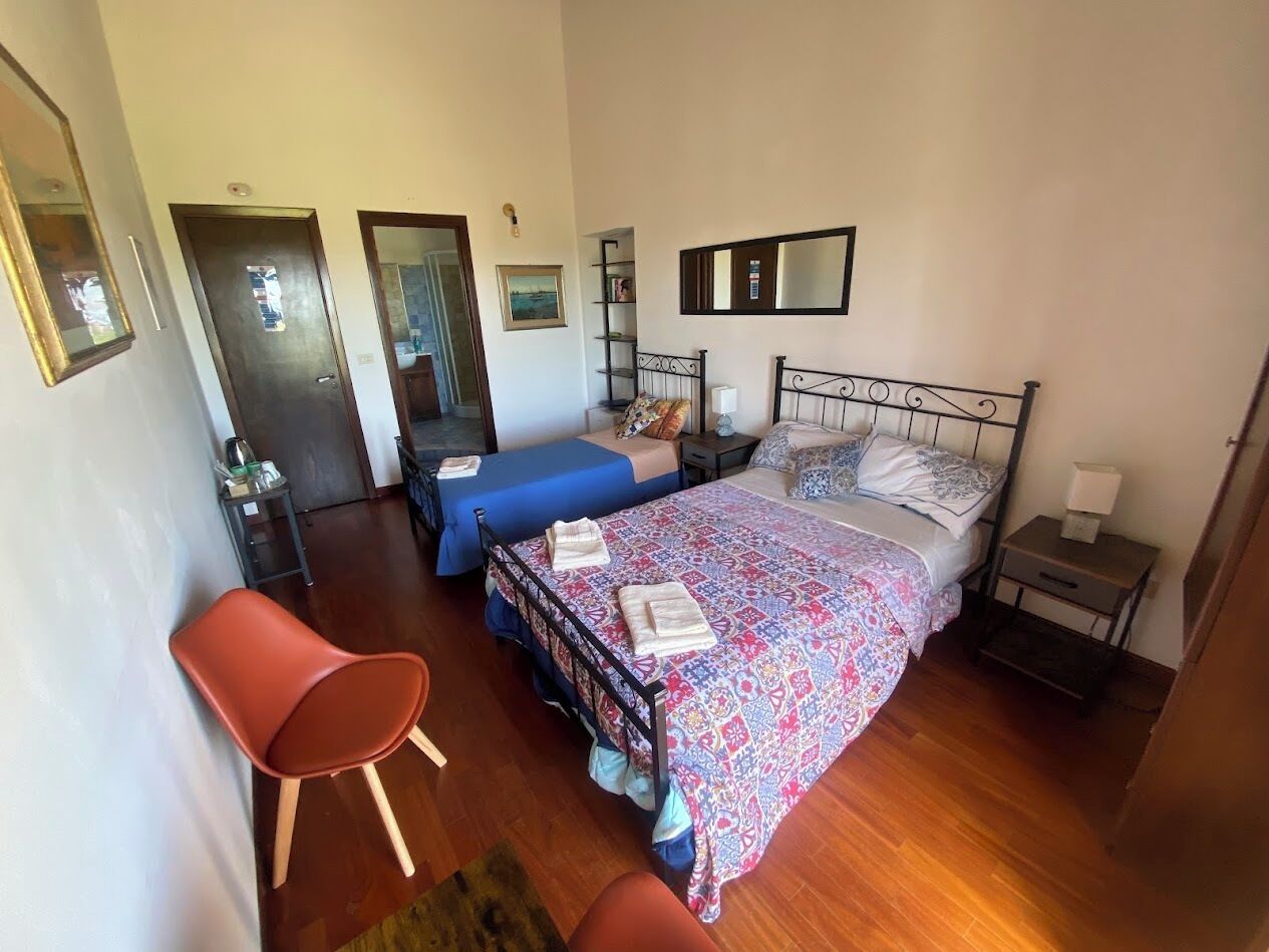 Une chambre à coucher comprenant un lit, une chaise, une table de chevet et une armoire.