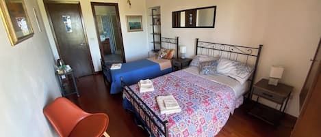 Un dormitorio con cama, una silla, una mesita de noche y un armario.