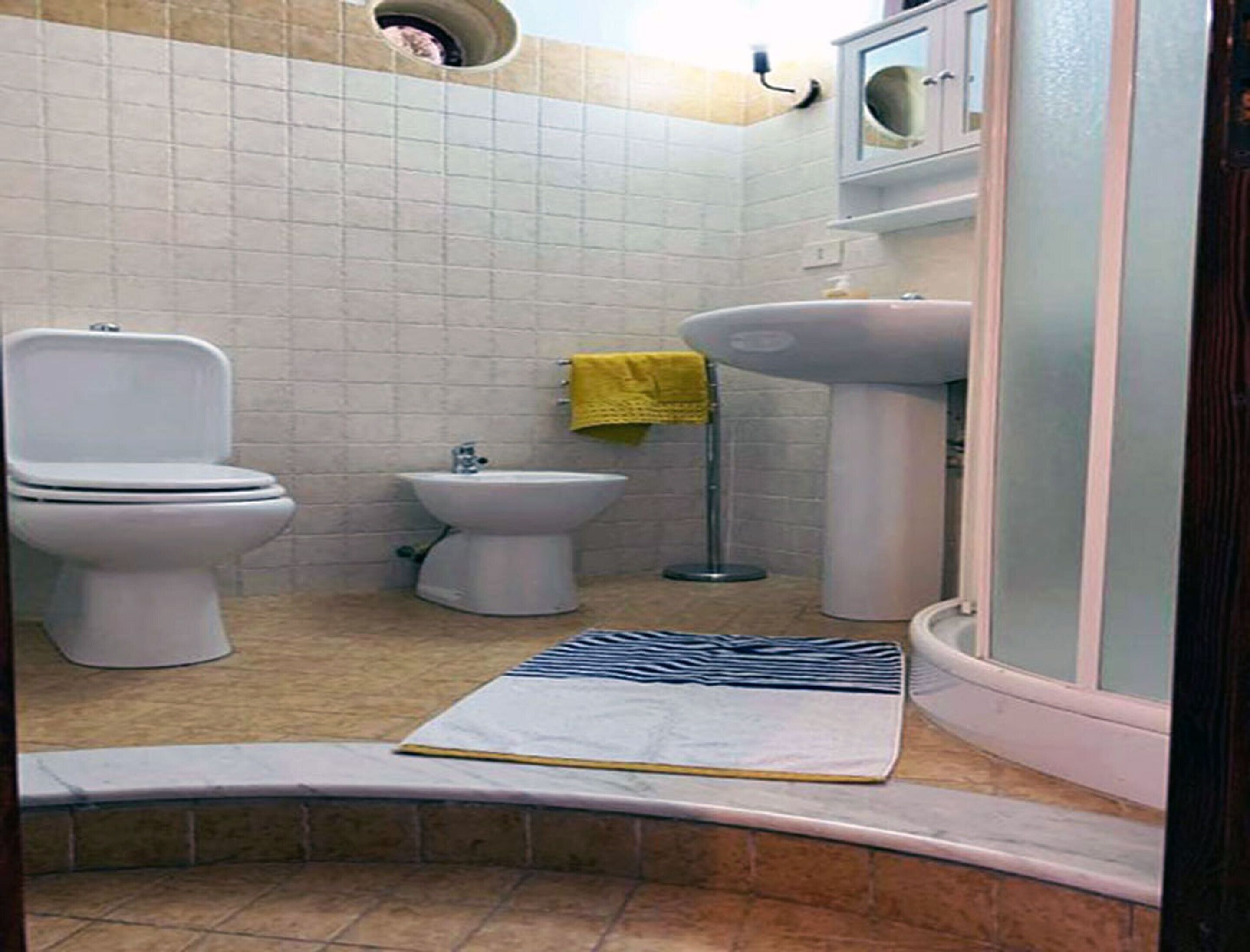Een badkamer met toilet, wastafel en bidet.