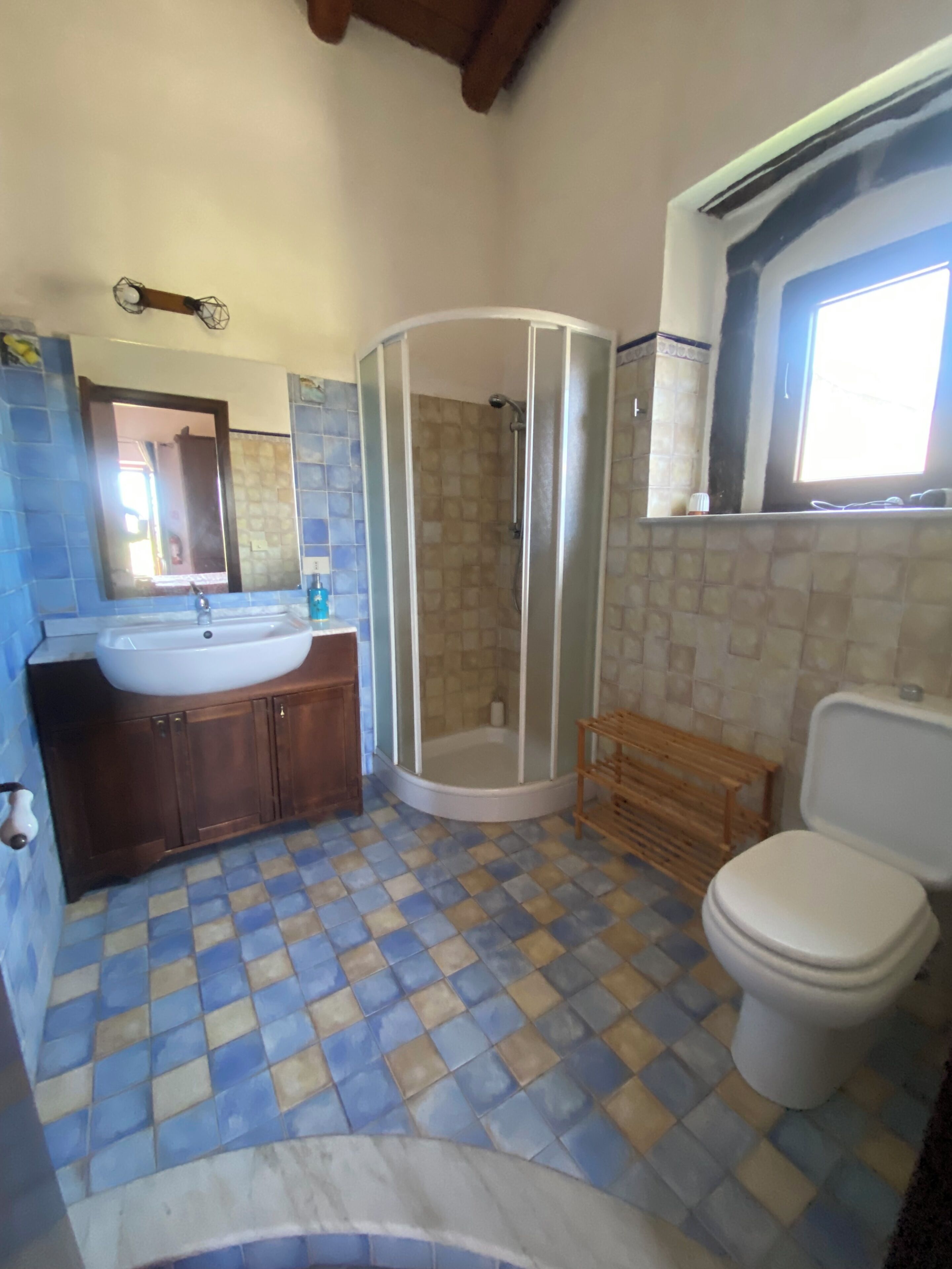 Ein Badezimmer mit Dusche, Toilette, Waschbecken und Spiegel.