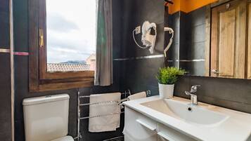 A modern bathroom with a toilet, sink, and towel rack.
