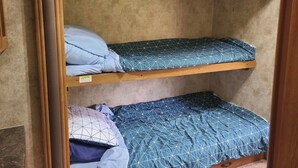 A bunk bed with two levels, each with a blue patterned mattress and pillows. - Riversides Copper Canyon! (Petit Étang)