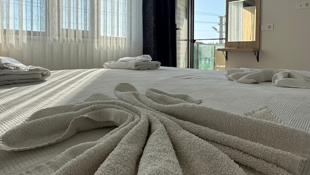 A modern hotel room with a large bed, a view of the outdoors, and a large window with curtains. - The Brothers Suite (Dalaman)