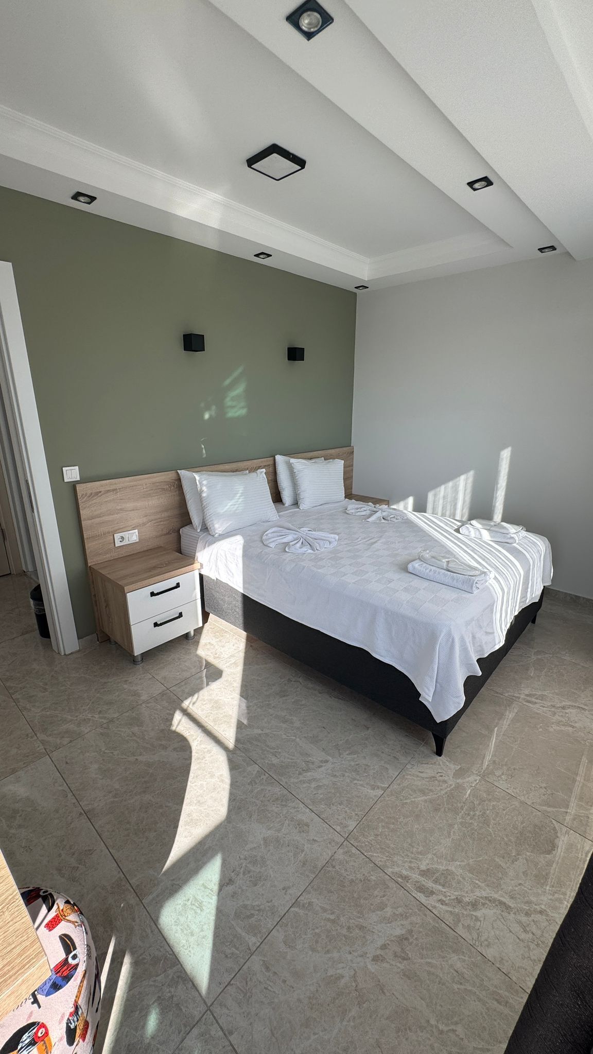 A modern bedroom with a large bed, bedside tables, and a nightstand.