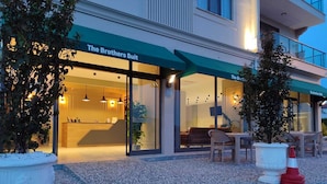 A hotel exterior with a reception desk, seating area, and outdoor seating. - The Brothers Suite (Dalaman)