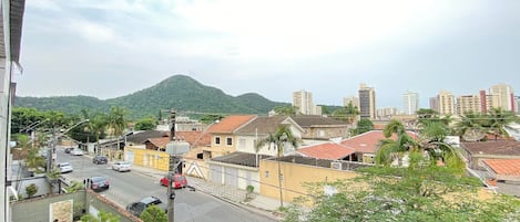 A residential area with buildings, a street, and a mountain in the background.