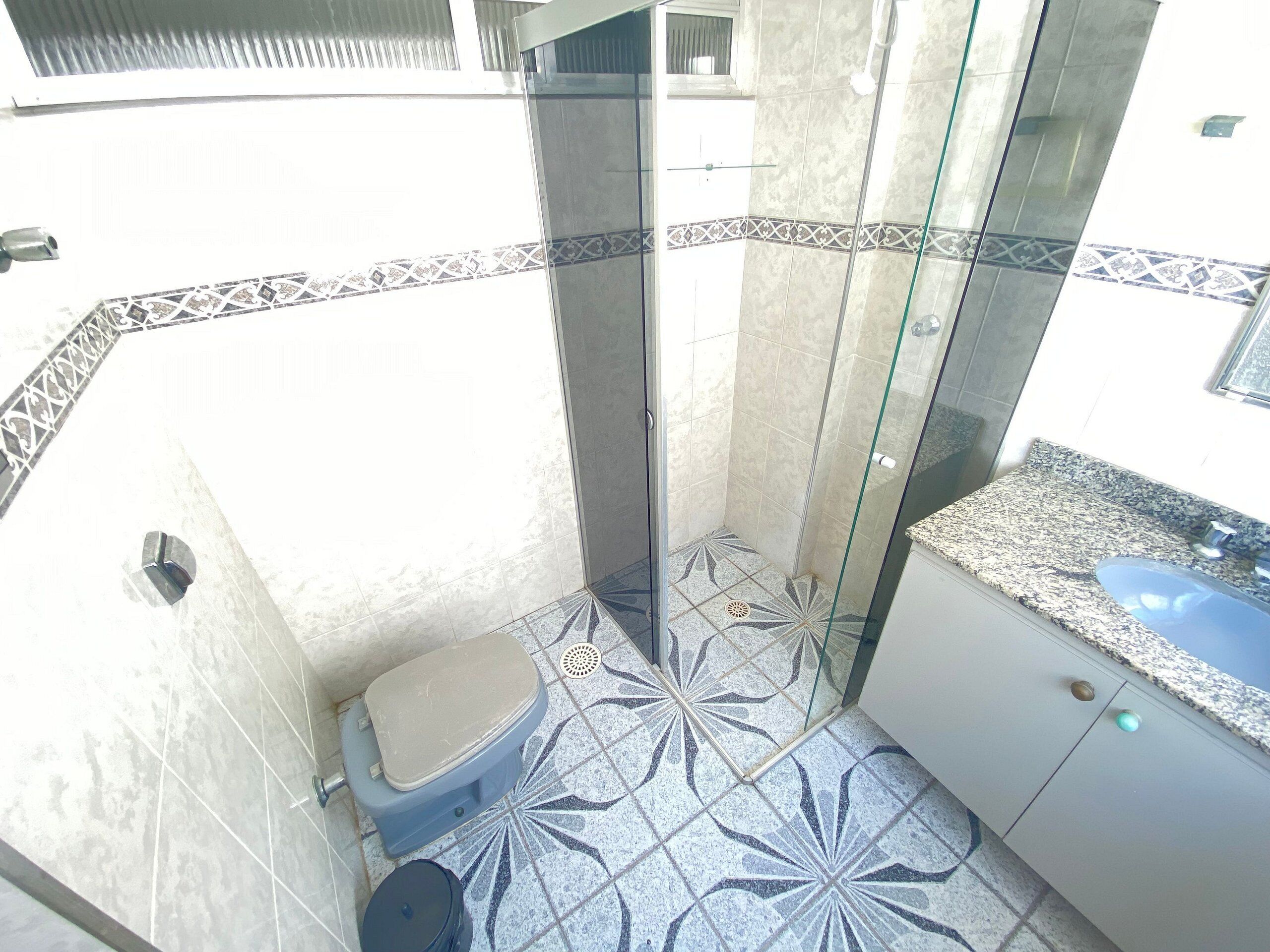 Une salle de bain avec des toilettes, une douche et un lavabo.