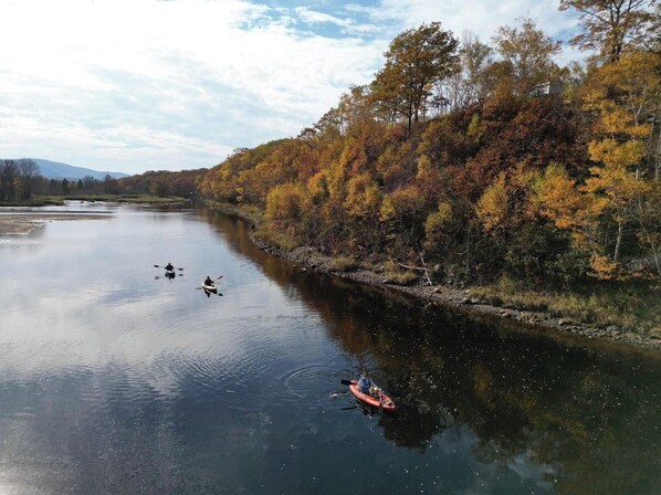 Une rivière paisible où l’on peut faire du kayak, bordée d’arbres aux couleurs automnales.
