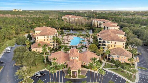 A resort with multiple buildings, a central swimming pool, and a parking area.