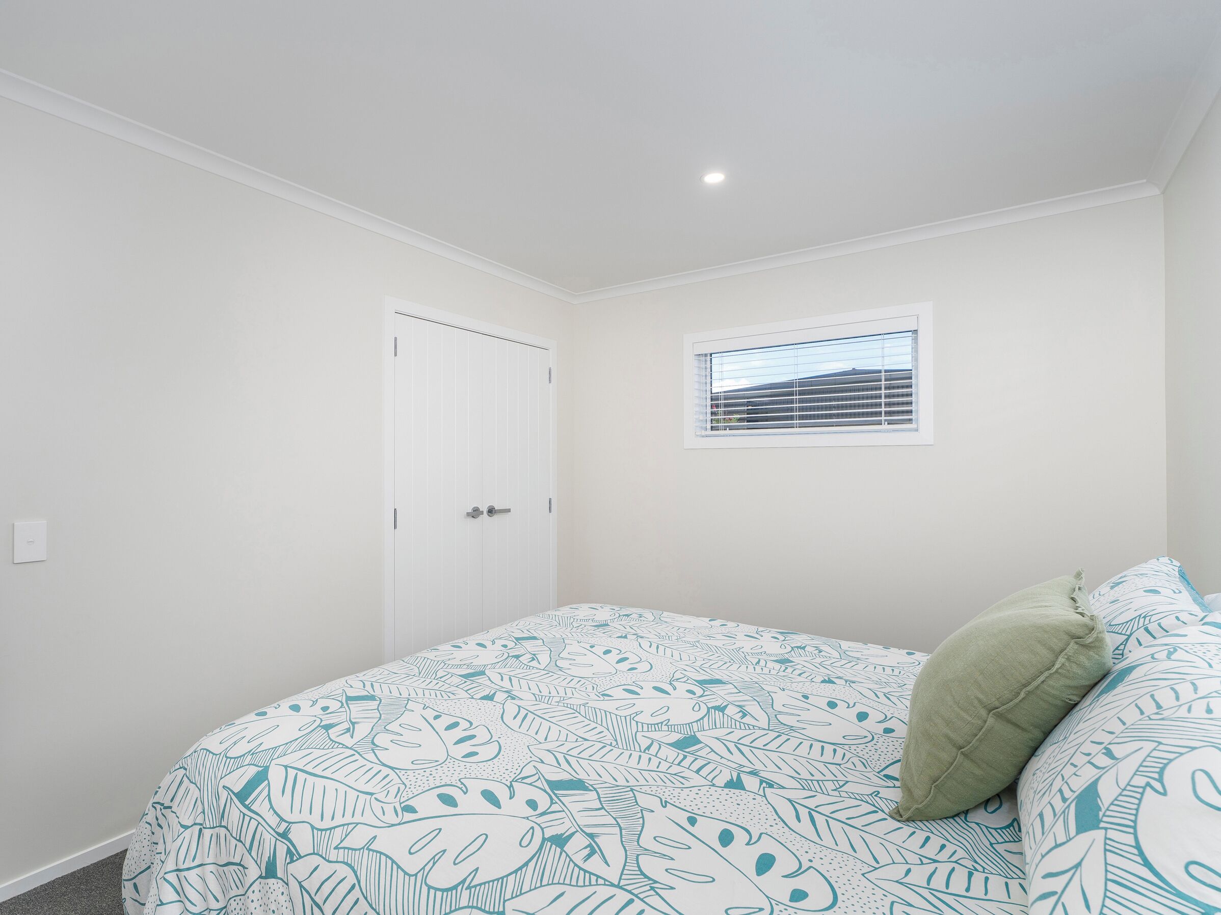 Une chambre à coucher avec un lit, une fenêtre et une porte.