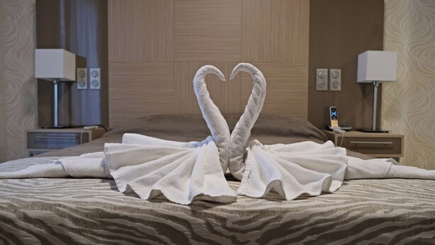 A hotel room with a bed featuring a towel arrangement in the shape of a heart. - Appart One Montreuil - Croix de Chavaux (Montreuil)