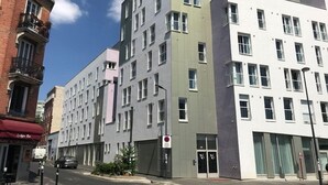 A multi-story building with a mix of modern and traditional architectural styles, featuring a variety of window sizes and building materials. - Appart One Montreuil - Croix de Chavaux (Montreuil)