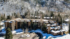 Ein Resort mit mehreren Gebäuden, einem zentralen Innenhof und bewaldeten Hügeln ringsherum.