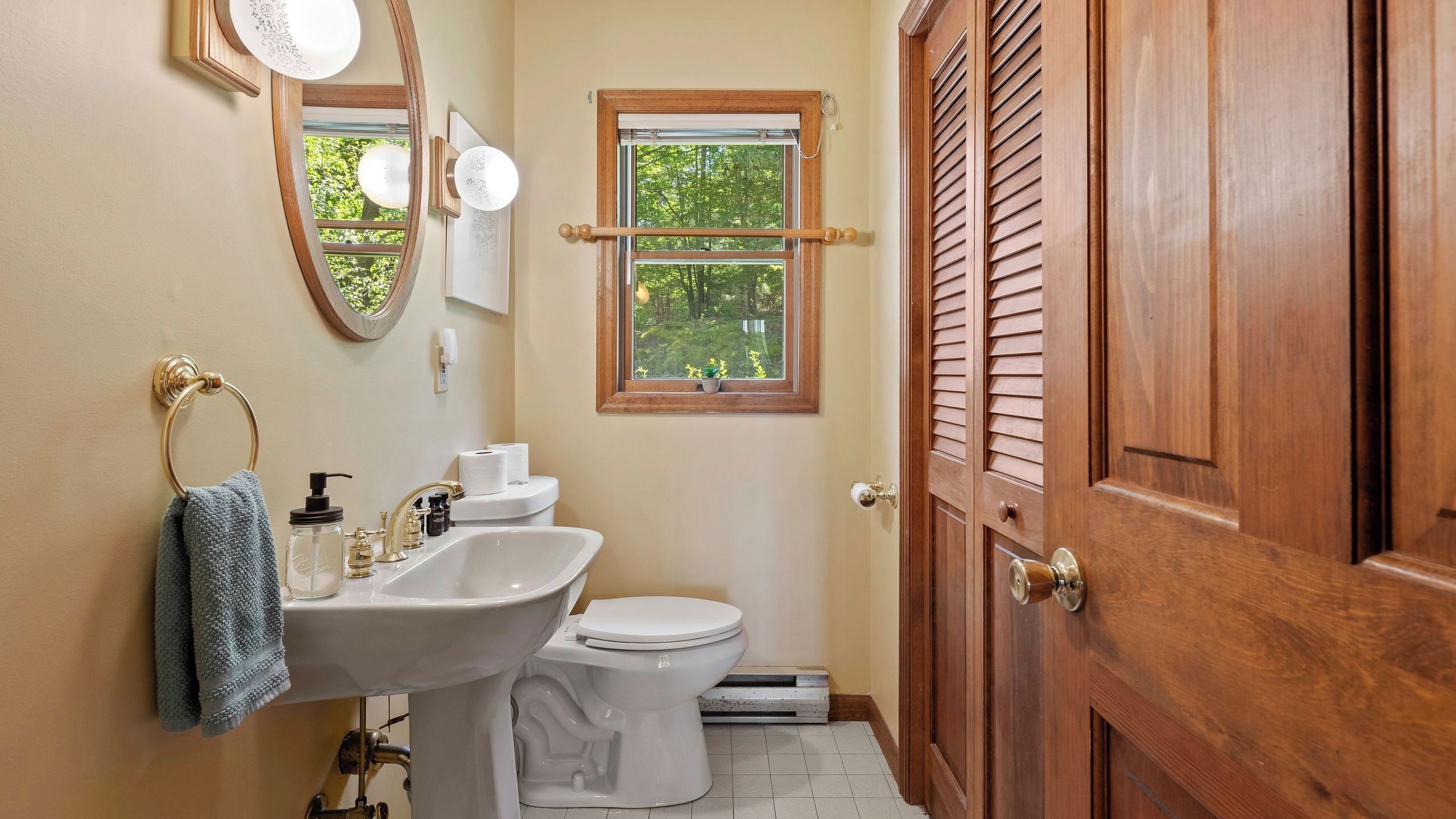 A bathroom with a sink, toilet, and wooden door.