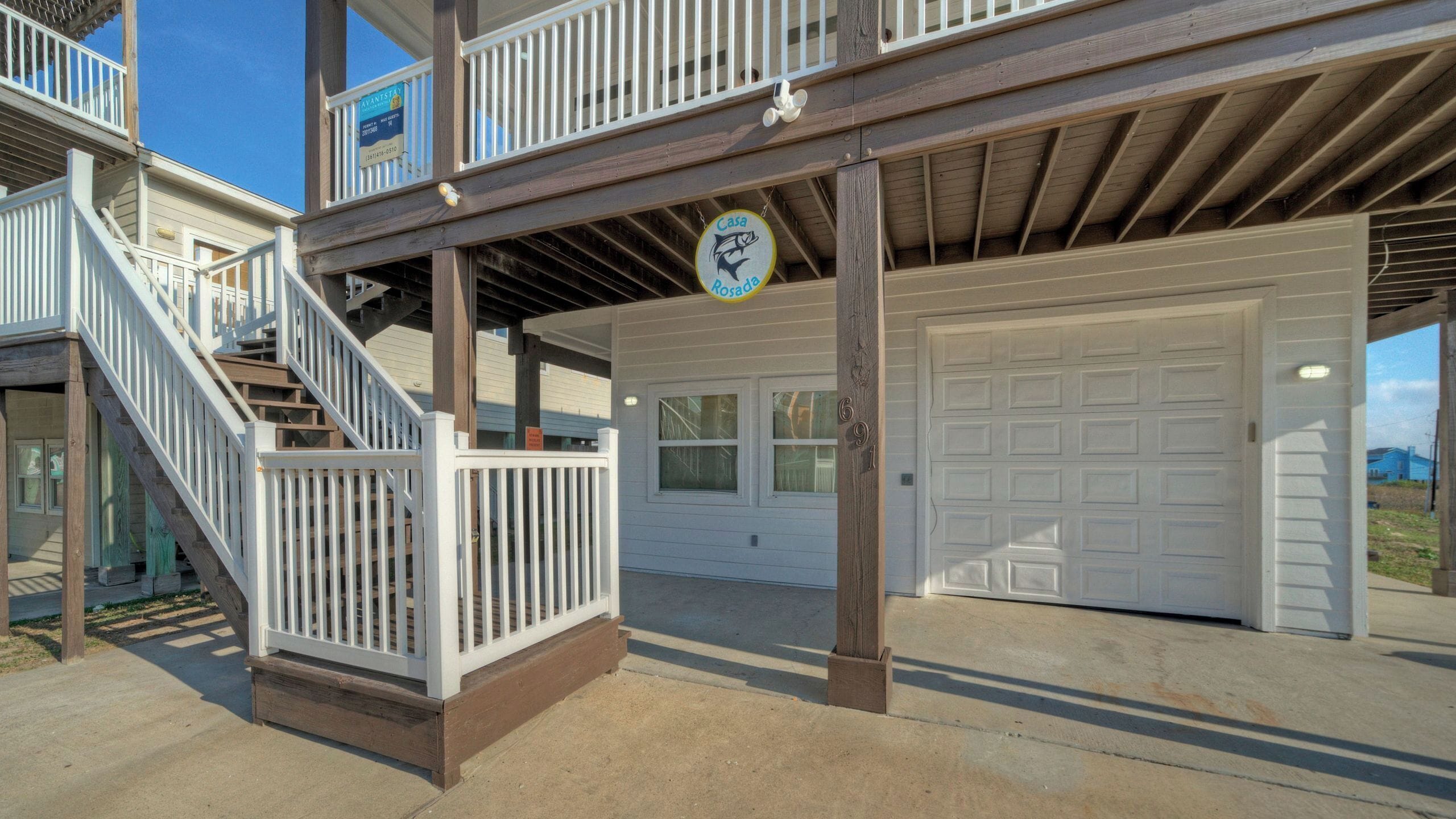 A two-story house with a covered porch, a garage, and a staircase leading to the upper level.