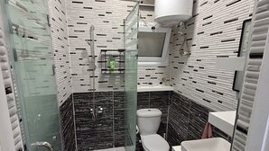 A bathroom with a glass-enclosed shower, a toilet, and a sink. - Egypt Hurghada Apartment  (Hurghada)