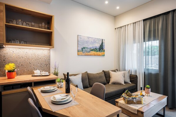 Un salon moderne avec une table à manger en bois, un canapé et un tableau accroché au mur.