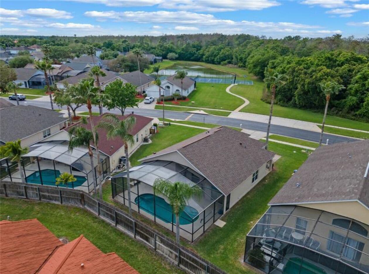 Zona residencial con casas, piscina y cancha de tenis.