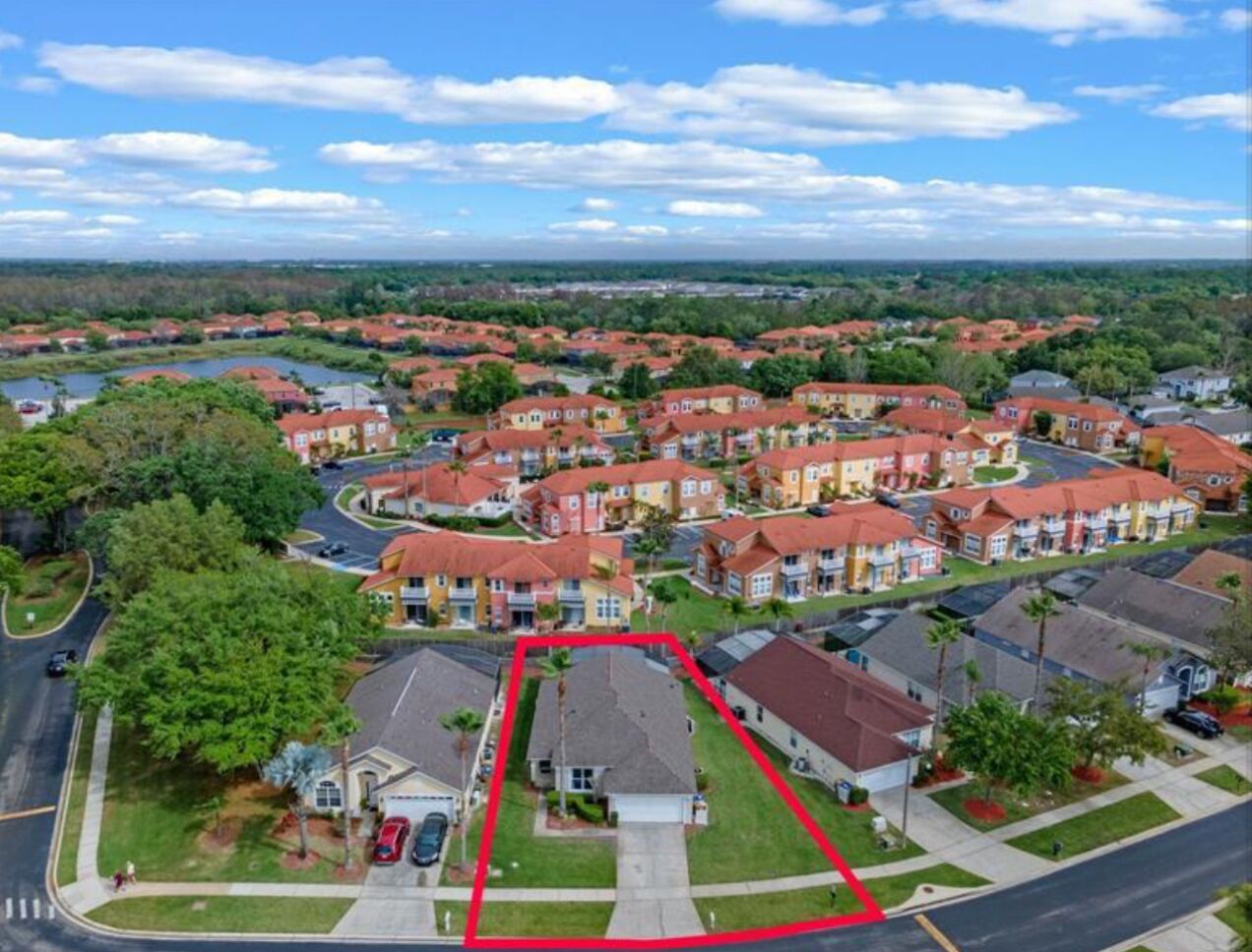 An aerial view of a residential area with houses, roads, and a body of water.