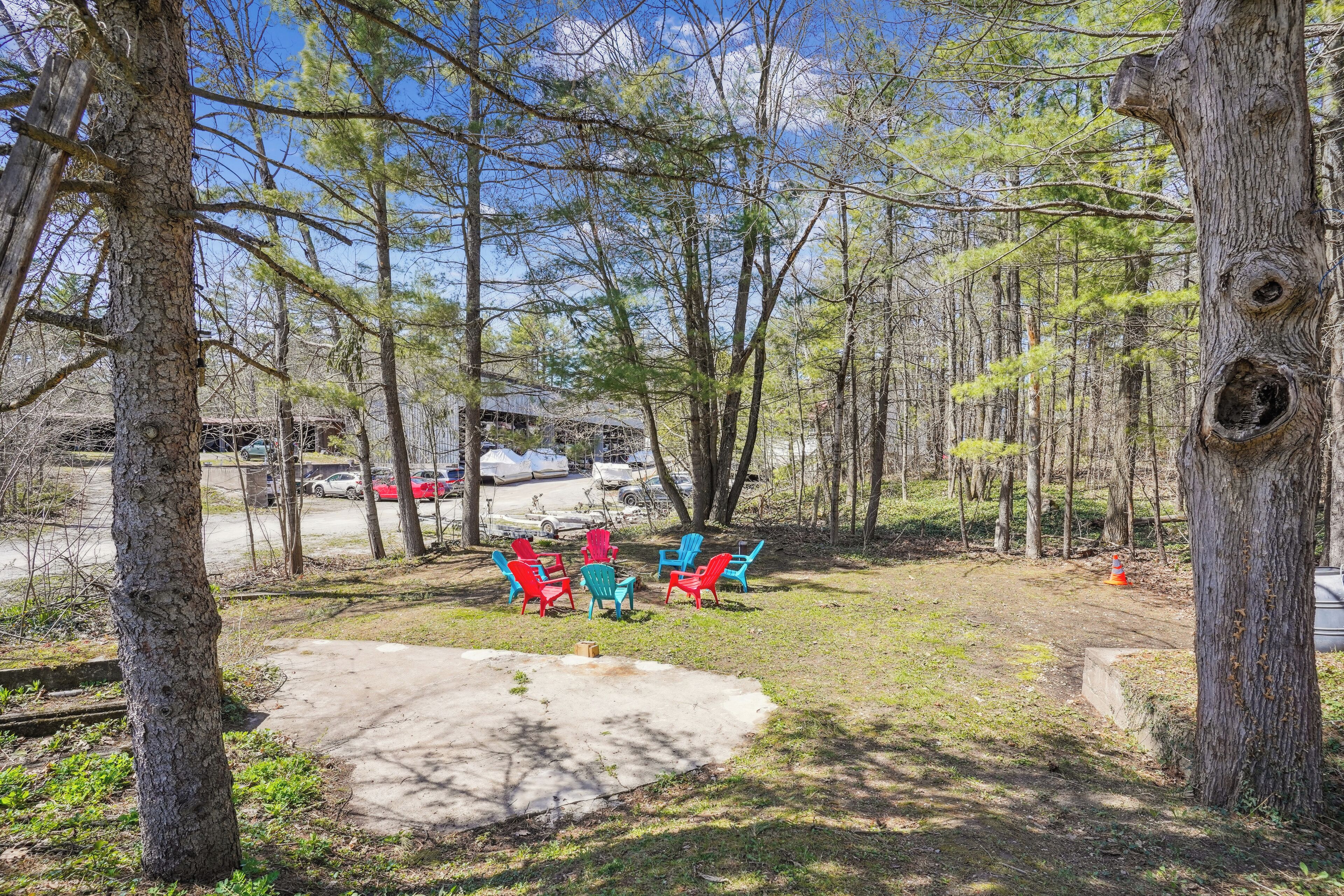 A campground with picnic tables and chairs, surrounded by trees.