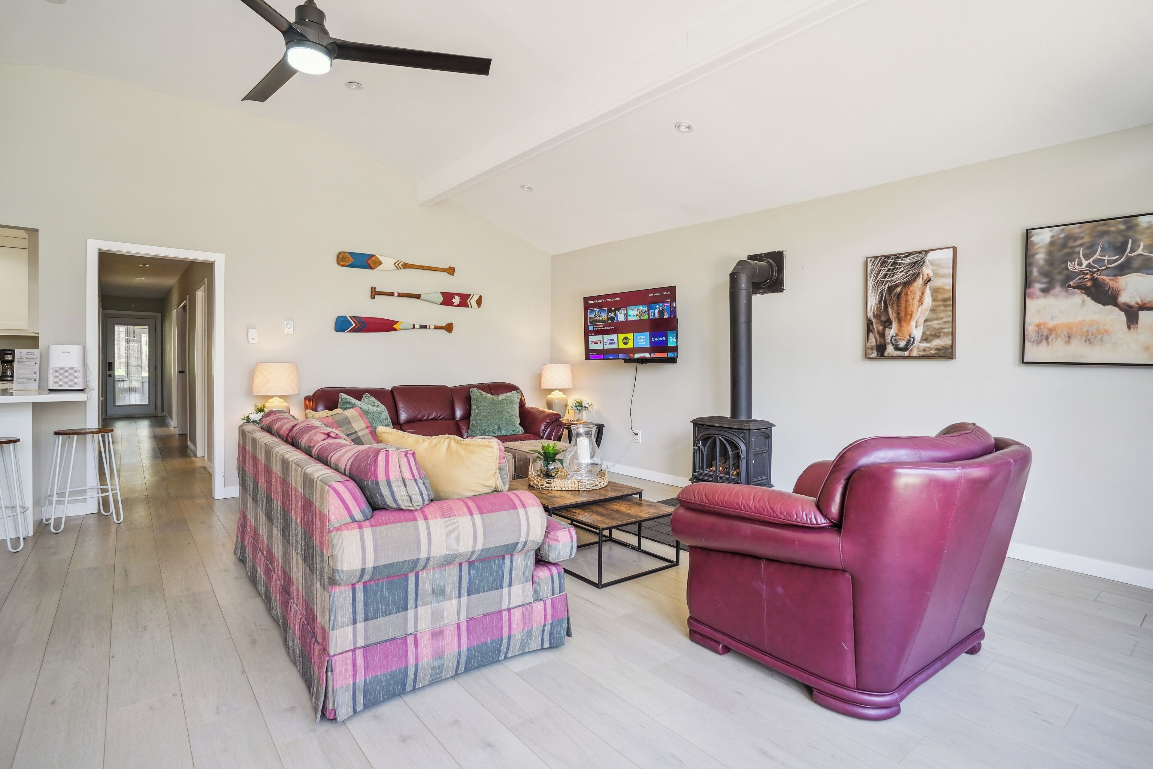 A living room with a sofa, a red chair, a fireplace, and wall-mounted decor.