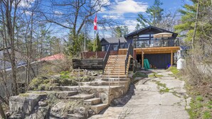 Une maison moderne avec un escalier en pierre menant à une terrasse en bois.