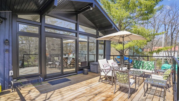 Une terrasse dotée de mobilier d’extérieur, d’une pergola et offrant une vue sur le jardin arrière.