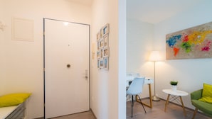 A room with a bed, a desk, a chair, a lamp, and a colorful abstract painting on the wall. - Vienna Residence, Rochusmarkt - Wien Mitte #6427 (Vienna)