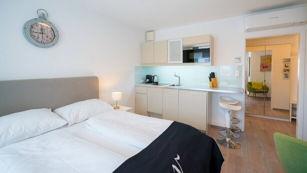 A hotel room with a bed, a small kitchenette, and a bathroom visible through an open door. - Vienna Residence, Rochusmarkt - Wien Mitte #6427 (Vienna)
