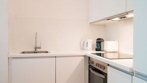 A compact kitchen with a sink, a kettle, a toaster, and an oven. - Vienna Residence Frankfurt, Schweizer Platz #6074 (Frankfurt)