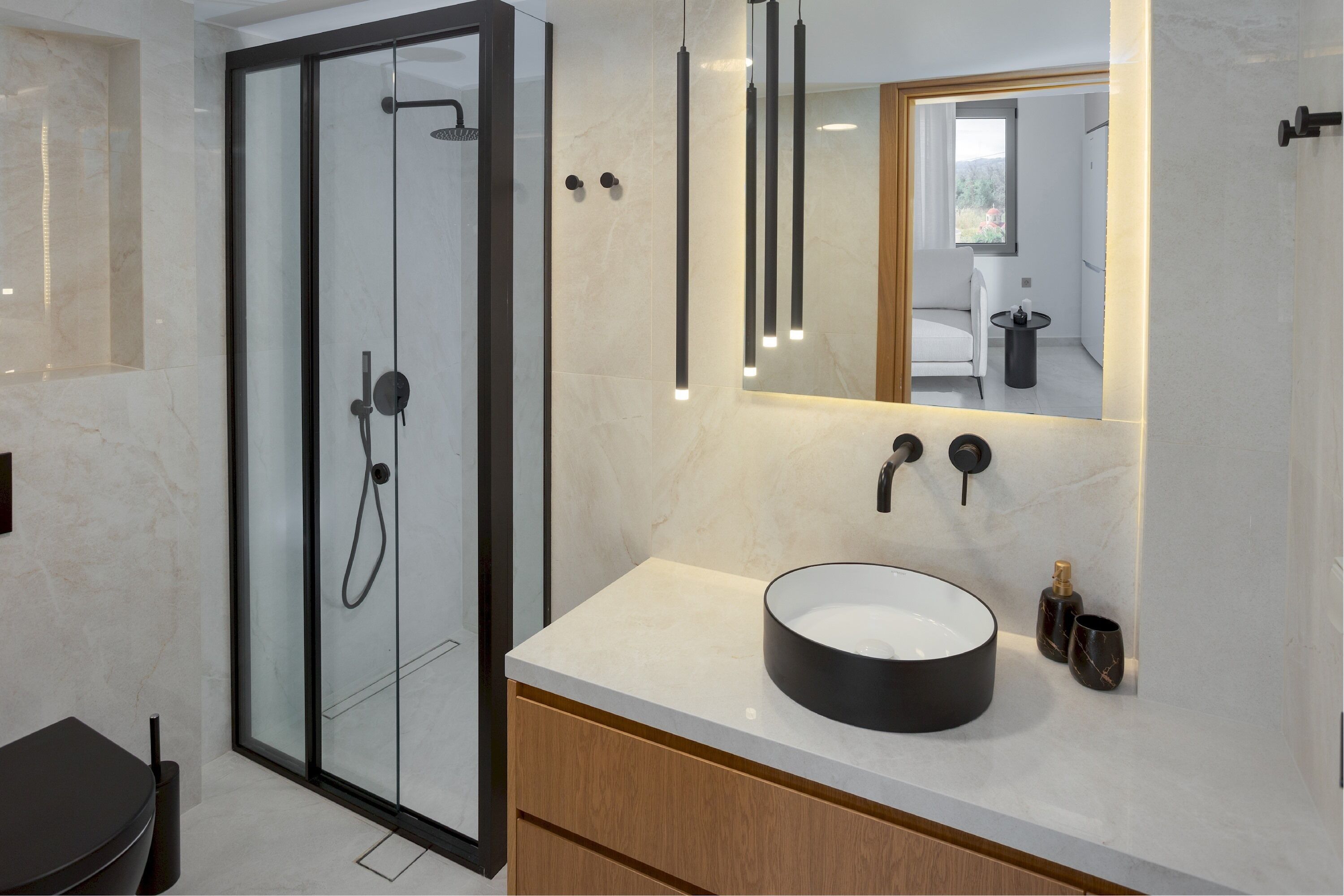 A modern bathroom with a glass-enclosed shower, a round sink, and a mirror above the vanity.