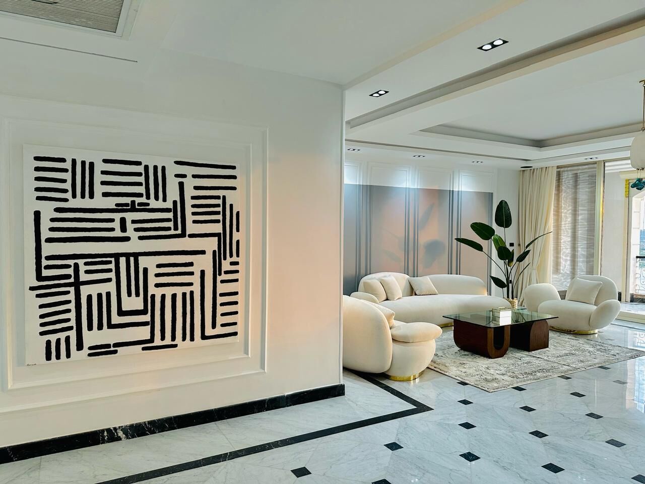 A modern living room with a geometric wall art, a sofa set, and a coffee table.
