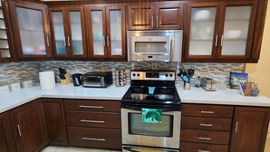 Una cocina con armarios de madera, horno de acero inoxidable, tostadora y microondas.