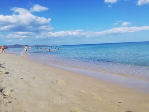 Una spiaggia con acqua cristallina e una riva sabbiosa.