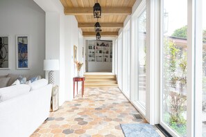 Un corridoio con pavimento piastrellato, una scala e vista all'esterno.