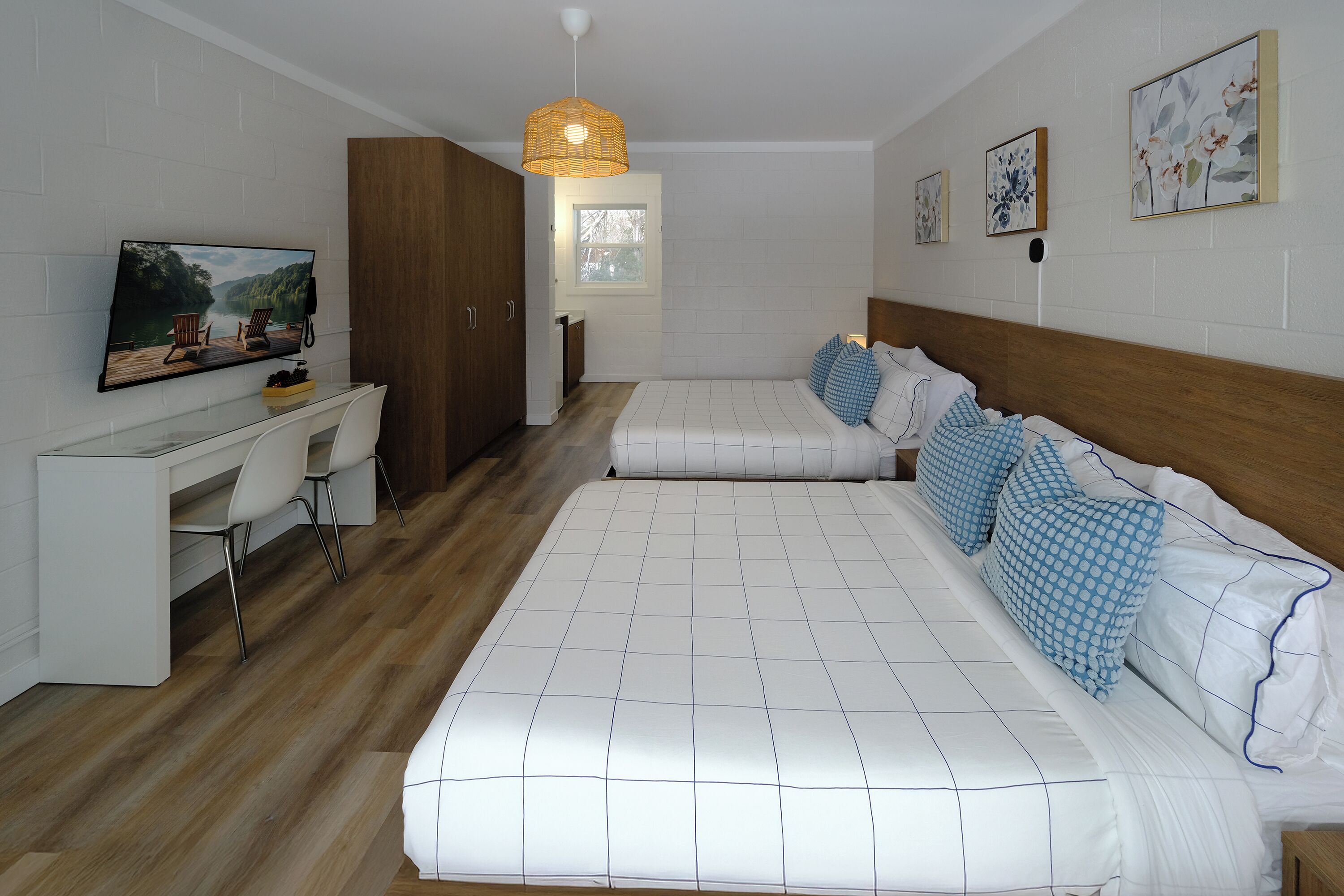 Un dormitorio con cama, escritorio y televisión.