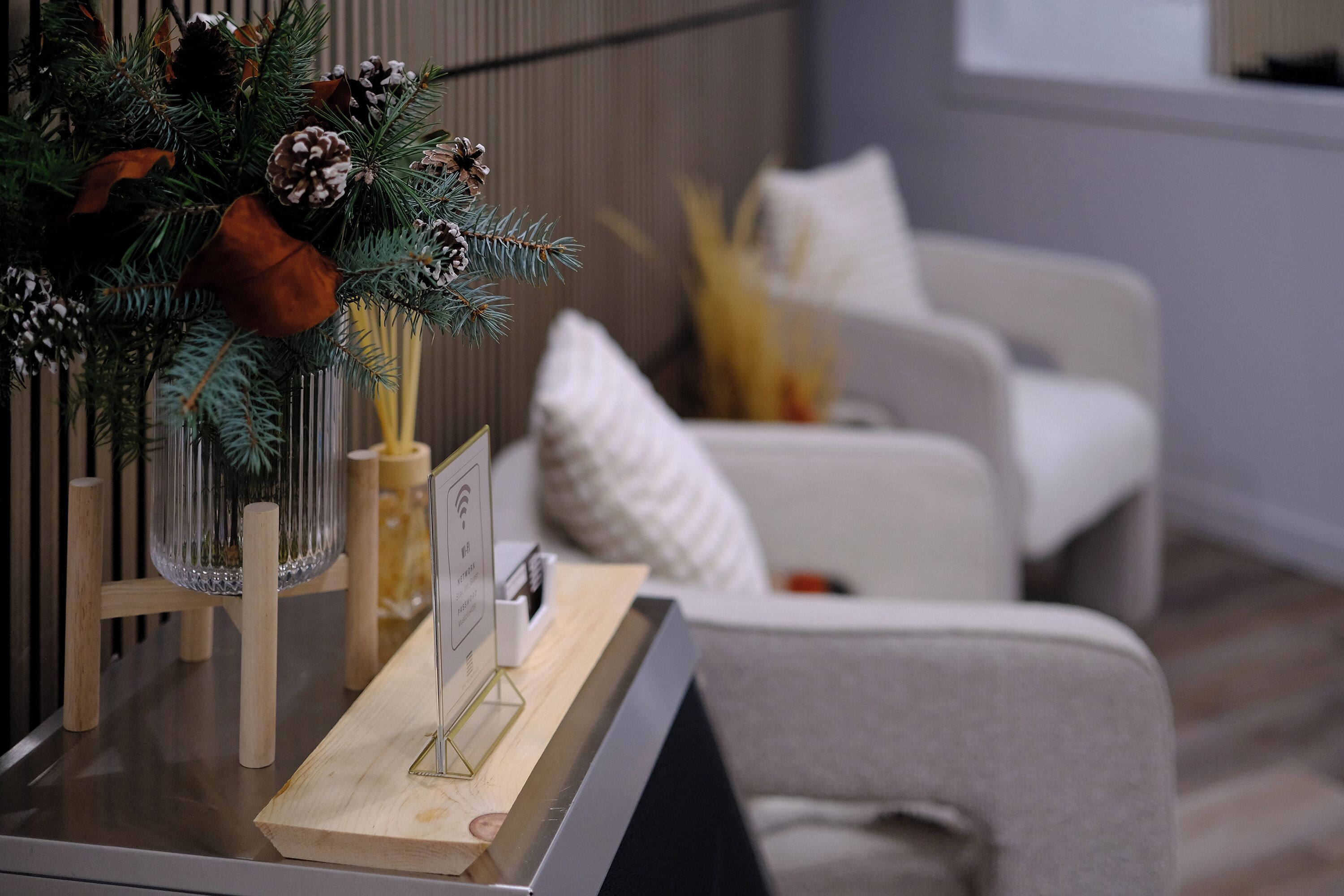 Una sala moderna con una mesa de centro de madera, un arreglo decorativo de plantas y un sofá blanco.