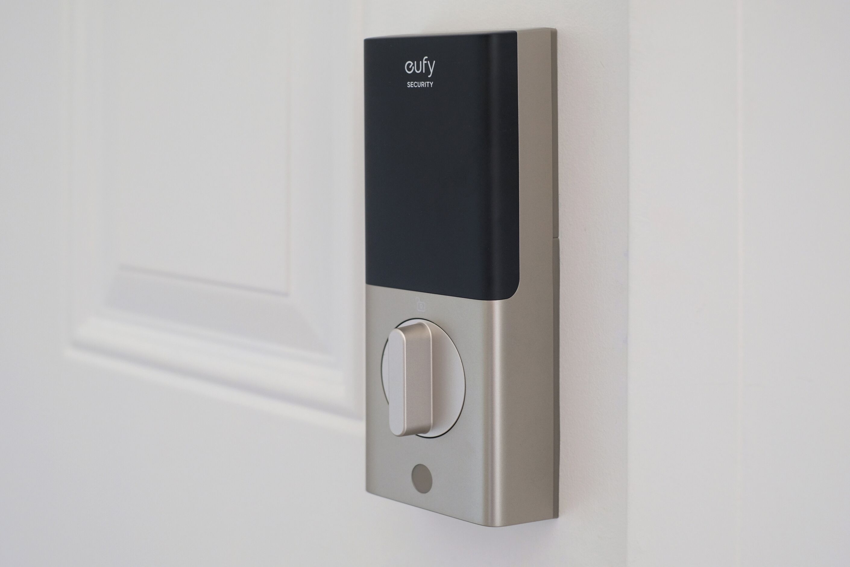 A door with a modern security device, including a keypad and a card reader, mounted on a metallic surface.
