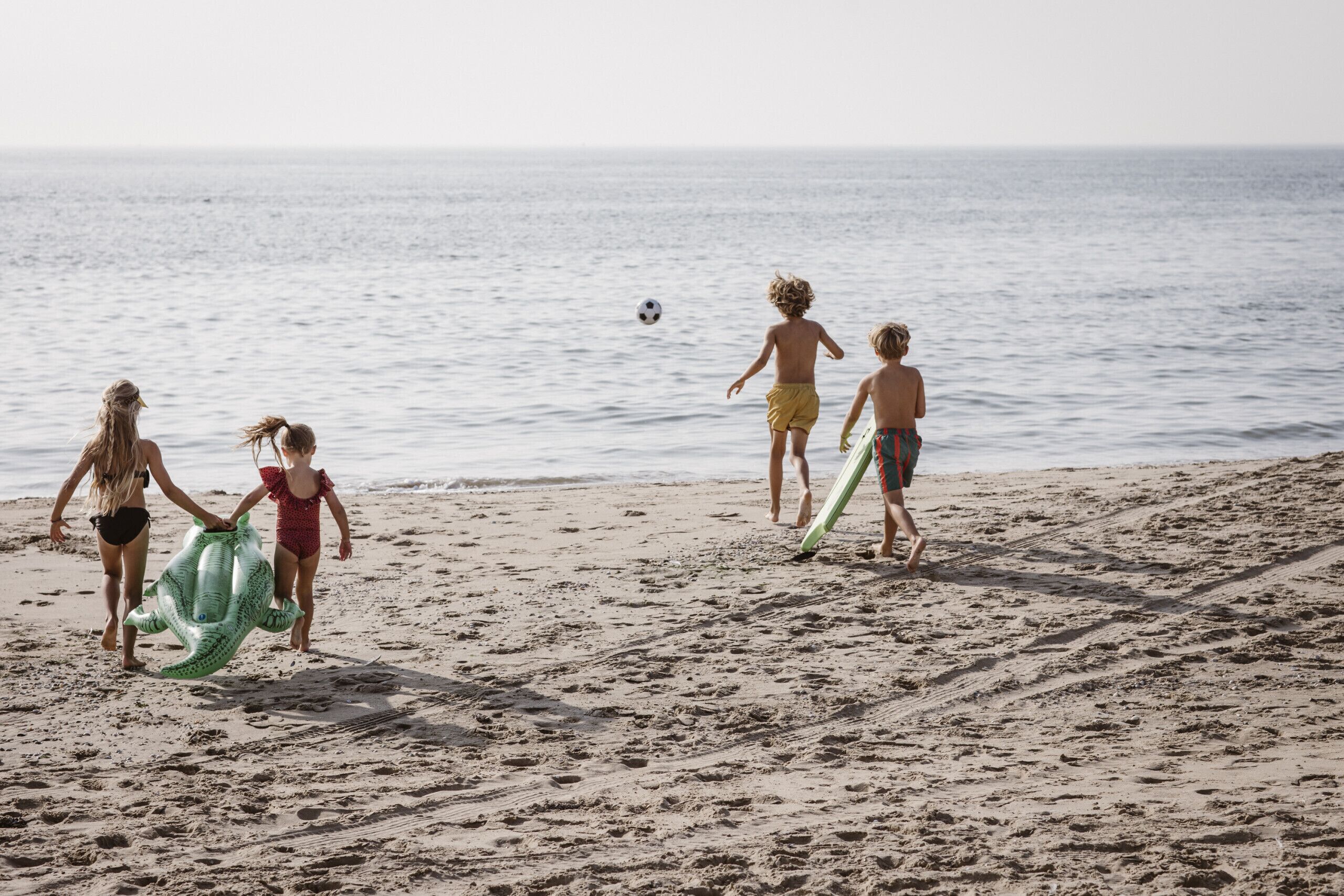 A sandy beach with footprints leading to the water.