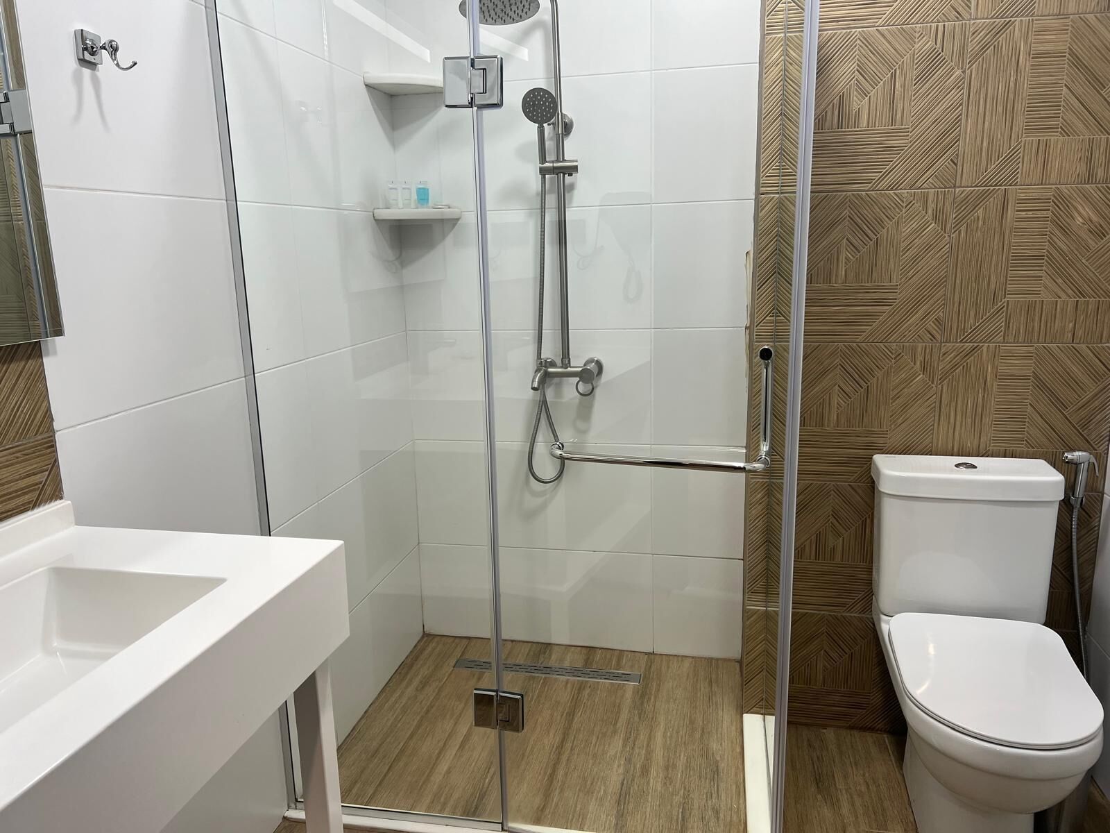 A modern bathroom with a shower, toilet, and sink.