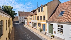 A narrow street lined with traditional European buildings, featuring a mix of architectural styles and a clear sky. - 3 bedroom lovely home in Faaborg (Faaborg)