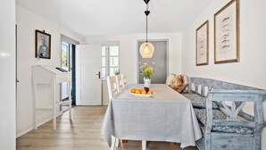 A dining area with a table set for four, a bench with cushions, and framed artwork on the walls. - 3 bedroom lovely home in Faaborg (Faaborg)